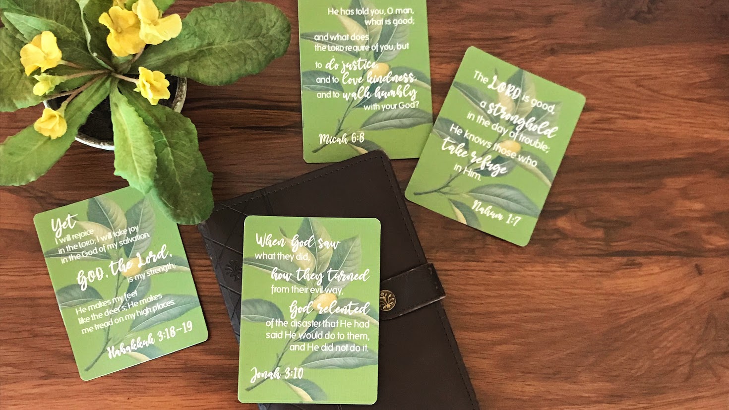 Green cards with text on a wooden surface with flowers