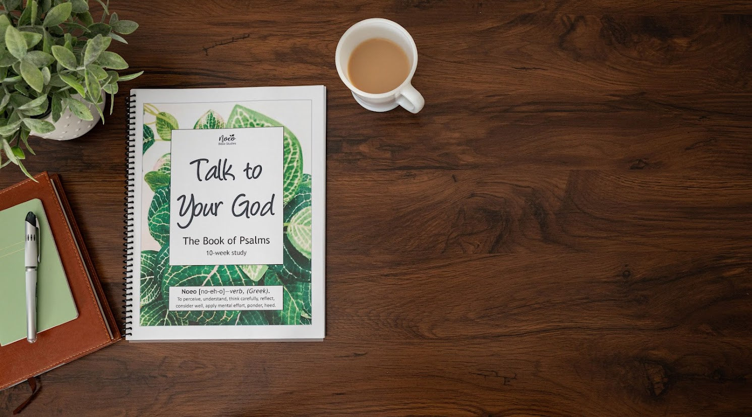 Workbook for Book of Psalms, with journal and coffee cup on wooden desk